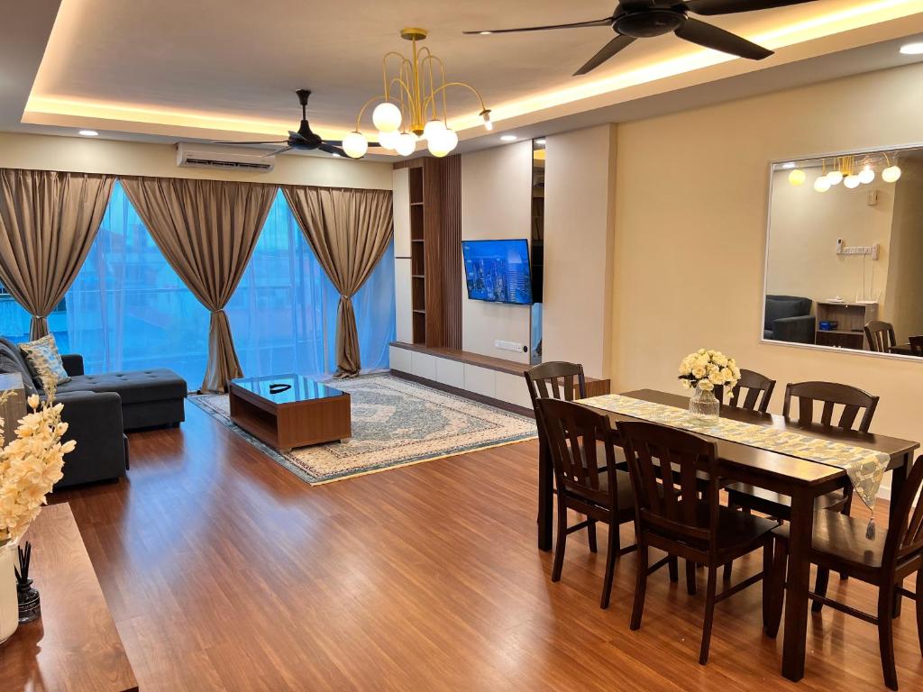 a dining room and living room with a table and chairs at Hermosa Homestay in Lahad Datu