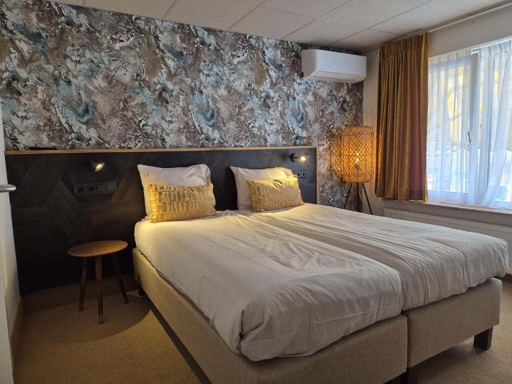Katwijk aan ZeeにあるZeevonk Studio's & Appartementenのベッドルーム1室(大型ベッド1台、黄色い枕付)