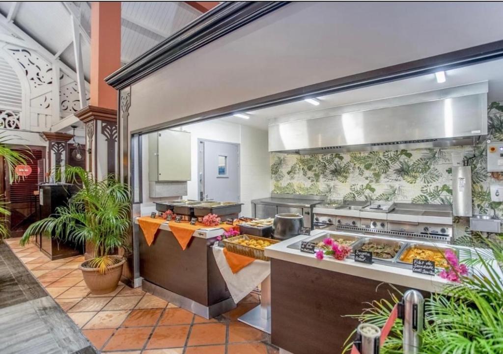 una grande cucina con molto cibo di Couleur Caraïbes-TI EVASION appartement dans un hôtel 3 étoiles vue mer a Sainte-Luce
