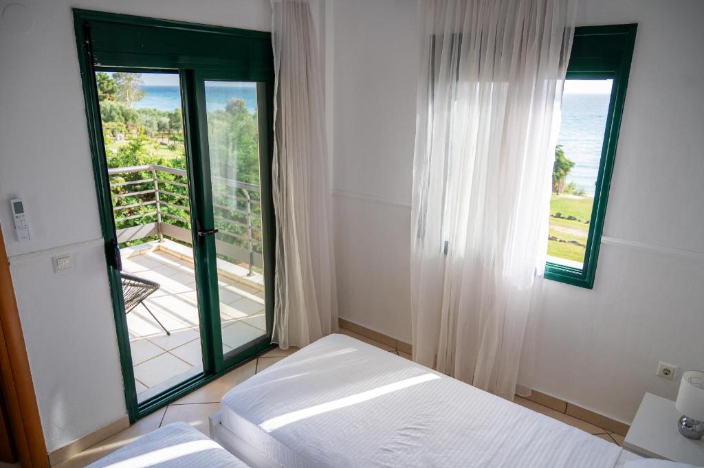a bedroom with a bed and a large window at Villa Jana - the Great Escape in Nea Skioni