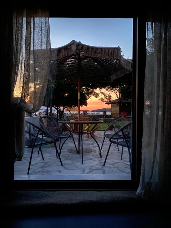 a view of a patio with a table and an umbrella at Akasti Slow Living in Paralia Sikias