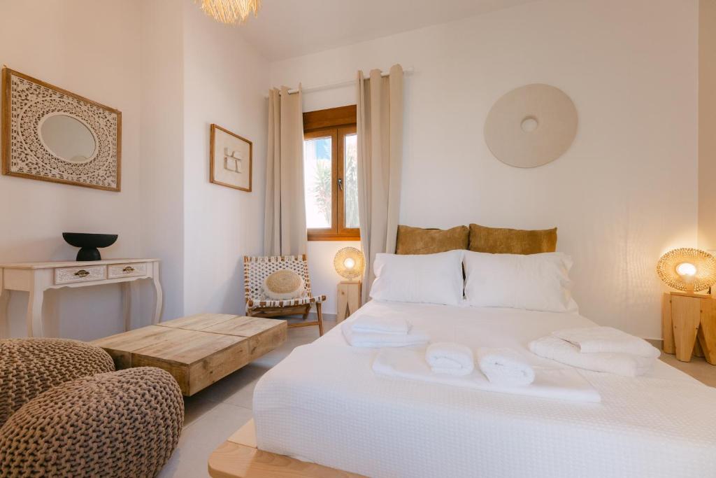 a white bedroom with a large bed and a couch at Naxian Harmony Town Suites in Naxos Chora