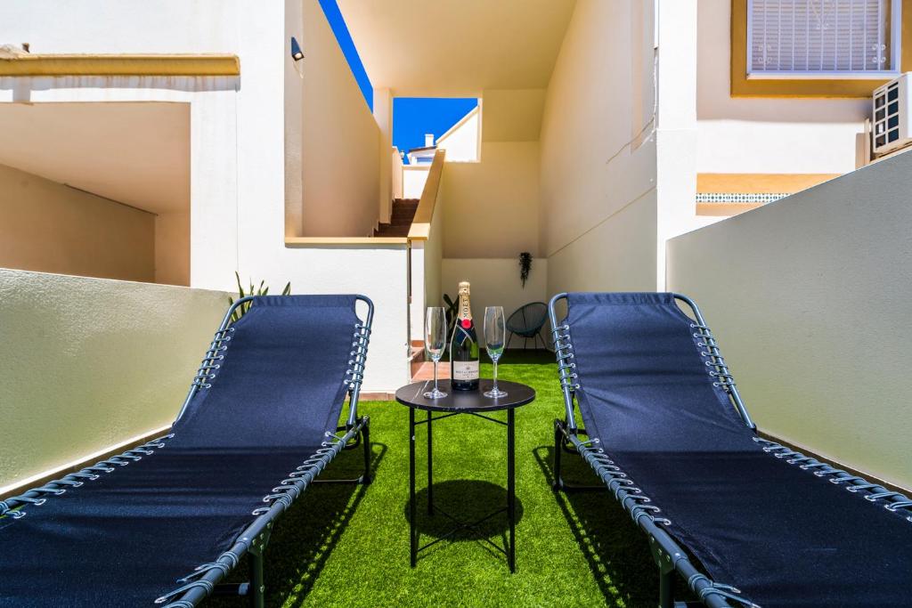 une chambre avec deux chaises bleues et une table dans l'établissement Exclusive Penthouse - Big Balcony & Private Garden, à Orihuela