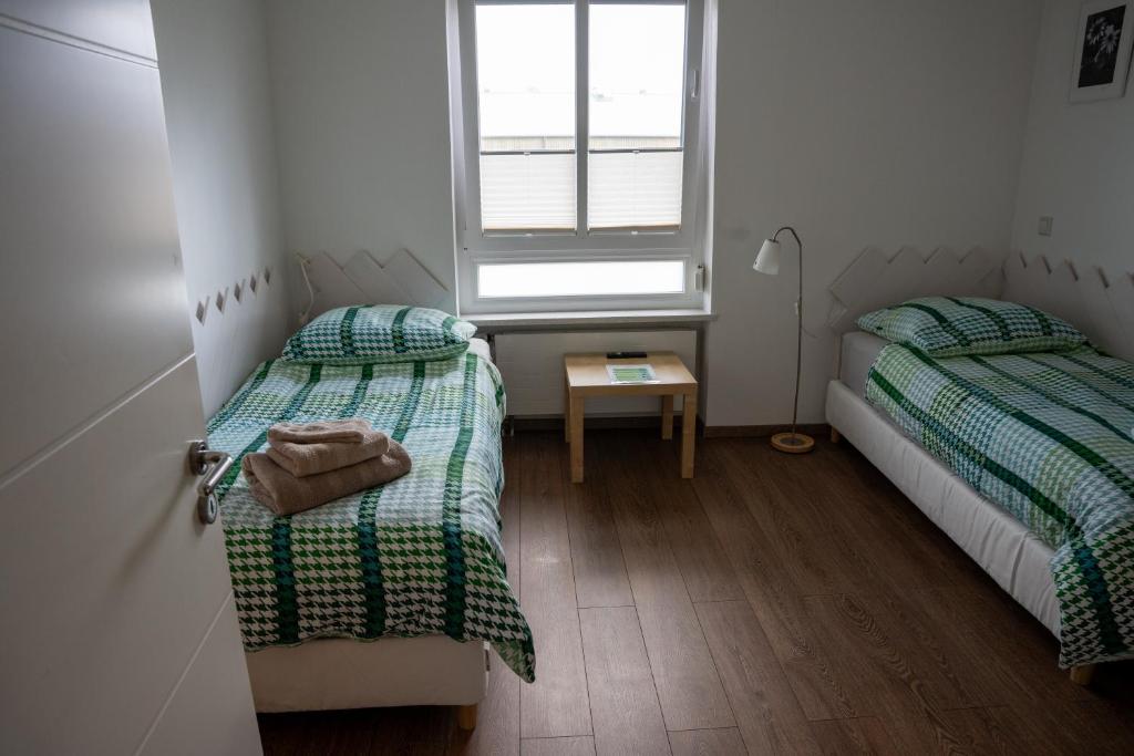 two beds in a small room with a window at A-Apartment Wolfsburg in Wolfsburg
