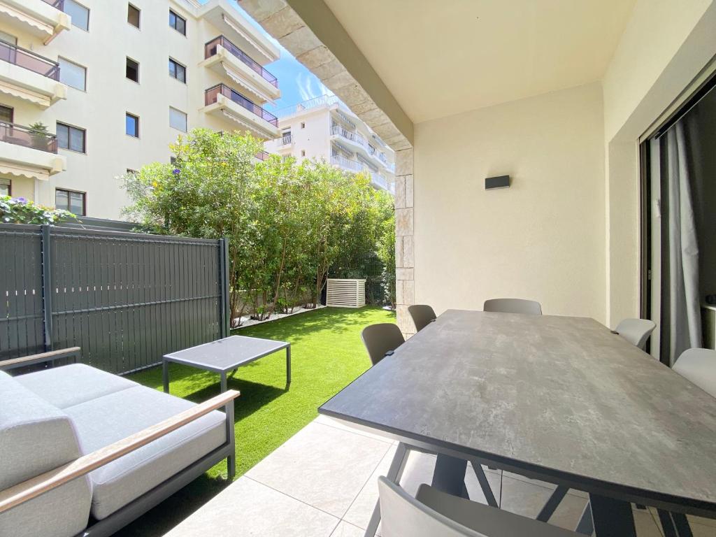 Cet appartement dispose d'une terrasse avec une table et des chaises. dans l'établissement Appartement Palm Beach Proche Croisette, à Cannes