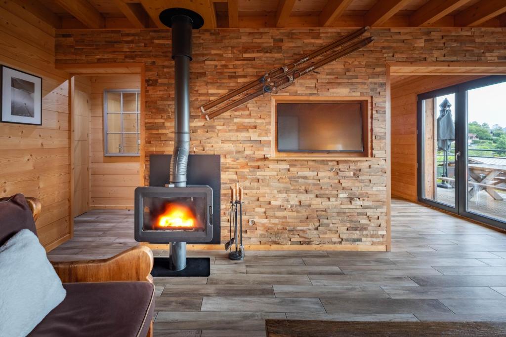 a fireplace in a room with a brick wall at Chalet La Souris, chaleureux avec vue panoramique in Gérardmer