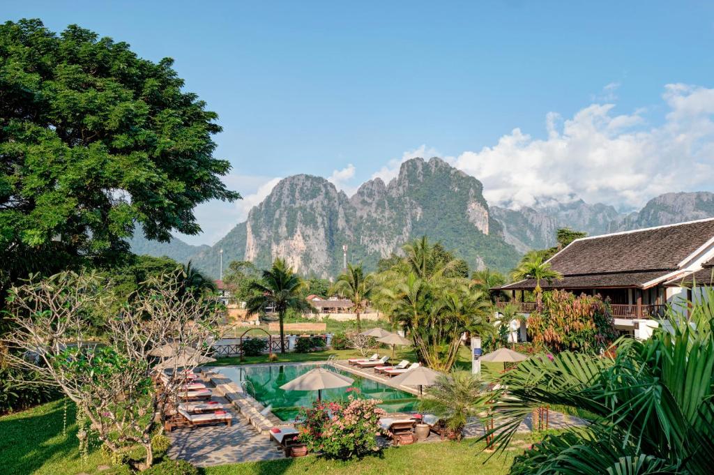 una vista aerea di un resort con montagne sullo sfondo di Riverside Boutique Resort, Vang Vieng a Vang Vieng