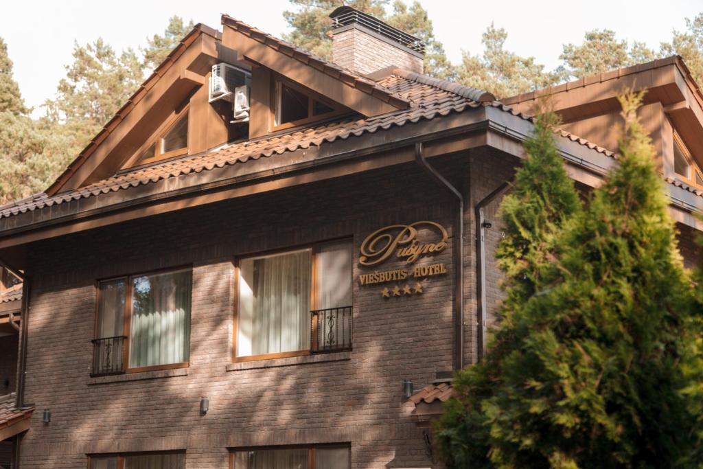 a building with a sign on the side of it at Pu&scaron;ynė in Bir&scaron;tonas