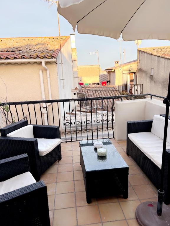 d'une terrasse meublée avec un parasol sur le balcon. dans l'établissement Maison de vacances, à Tourbes