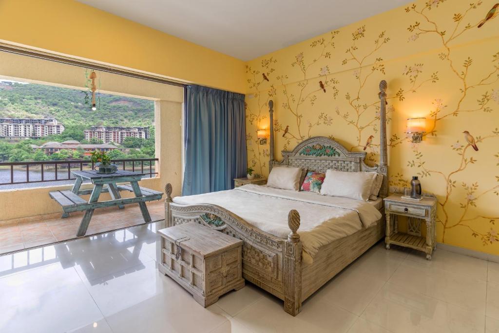 a bedroom with a bed with a yellow wall at Lavasa Holiday Home (Lakeview) in Lavasa
