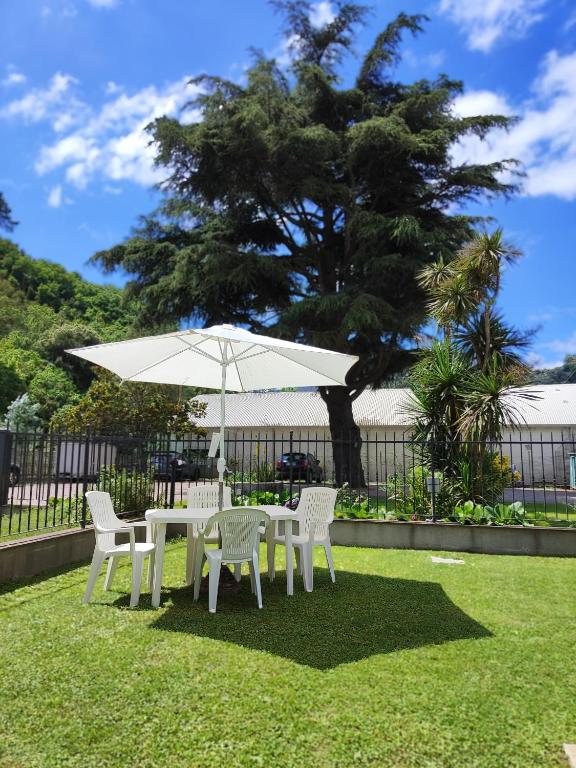 a white table and chairs with an umbrella at Marino Apartments in Levanto