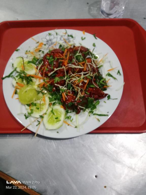 un piatto bianco di cibo su un vassoio rosso di Hotel Darsan and Lodge Taplejung a Tāplejung