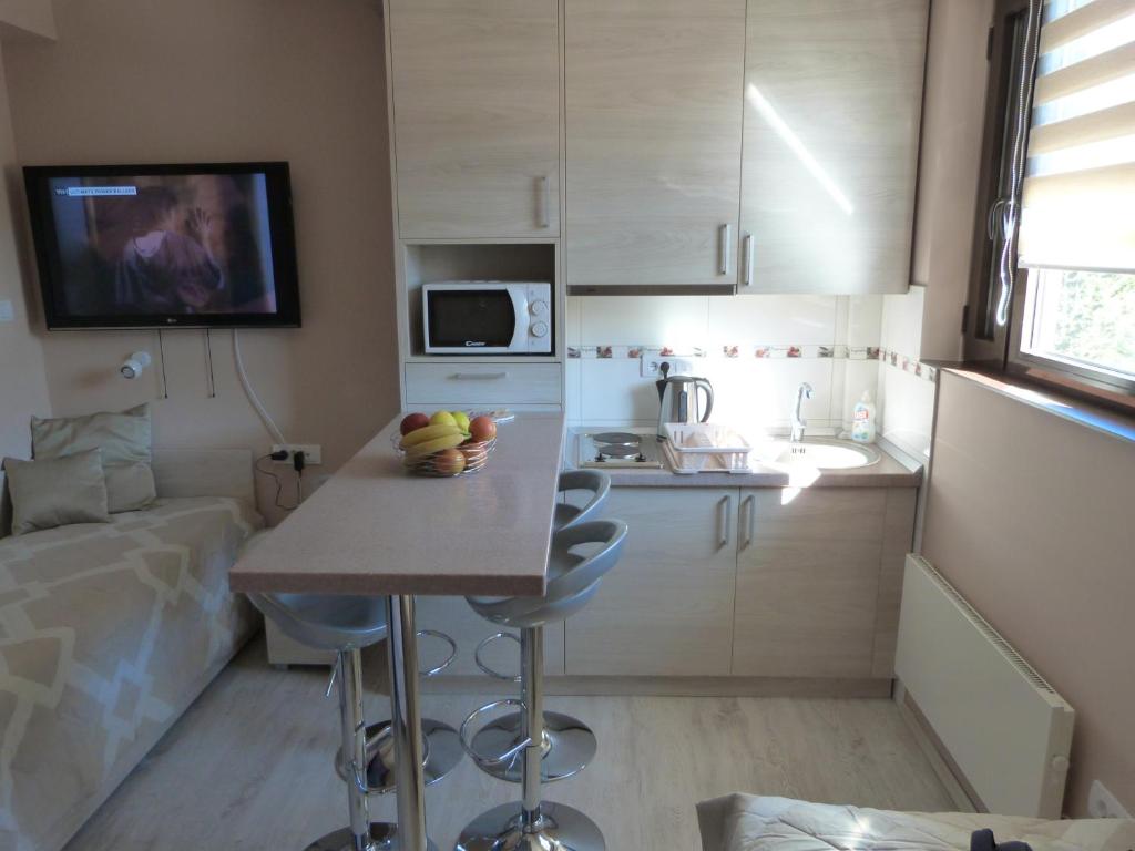una pequeña cocina con mesa y microondas en Apartments Sia, en Kopaonik