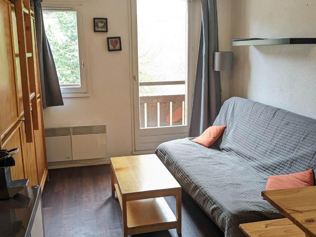 a living room with a couch and a window at Studio central avec balcon et vues sur pistes - 3 couchages - FR-1-557-44 in Les Adrets