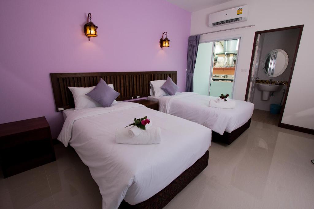 a bedroom with two beds with flowers on them at BS Airport at Phuket in Nai Yang Beach