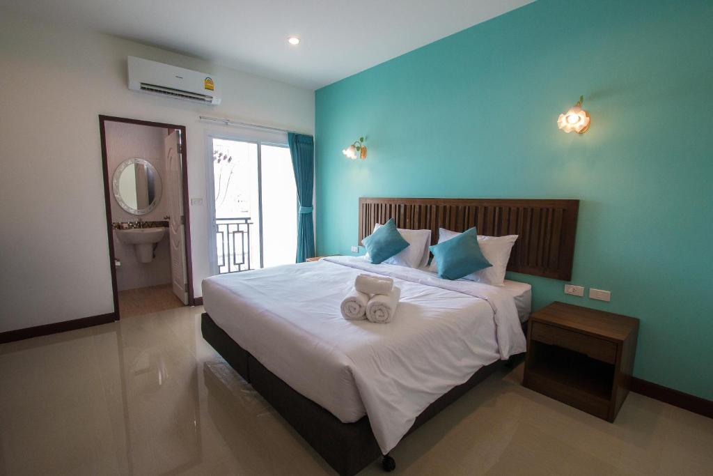 a bedroom with a bed with two teddy bears on it at BS Airport at Phuket in Nai Yang Beach