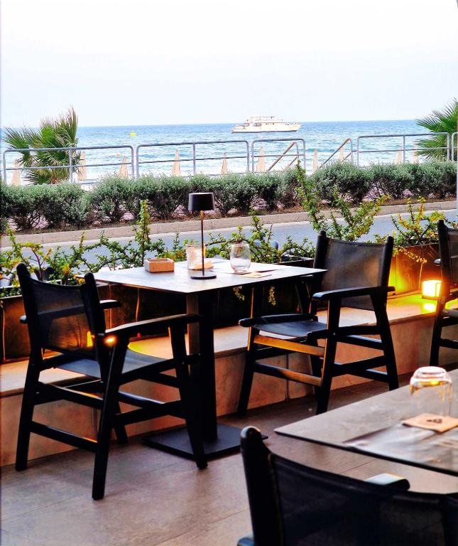 a table and chairs with a view of the ocean at The Ciao Stelio Deluxe Boutique Hotel - Adults Only in Larnaka