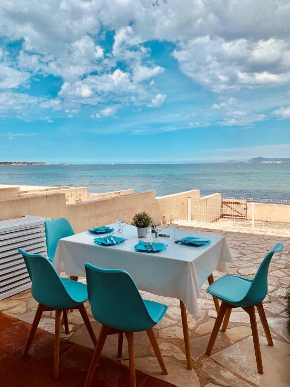 une table et des chaises avec l'océan en arrière-plan dans l'établissement studio climatisé les pieds dans l'eau, à Six-Fours-les-Plages