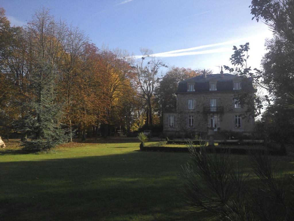 a large house in the middle of a field at Manoir de la Marjolaine in Cabourg