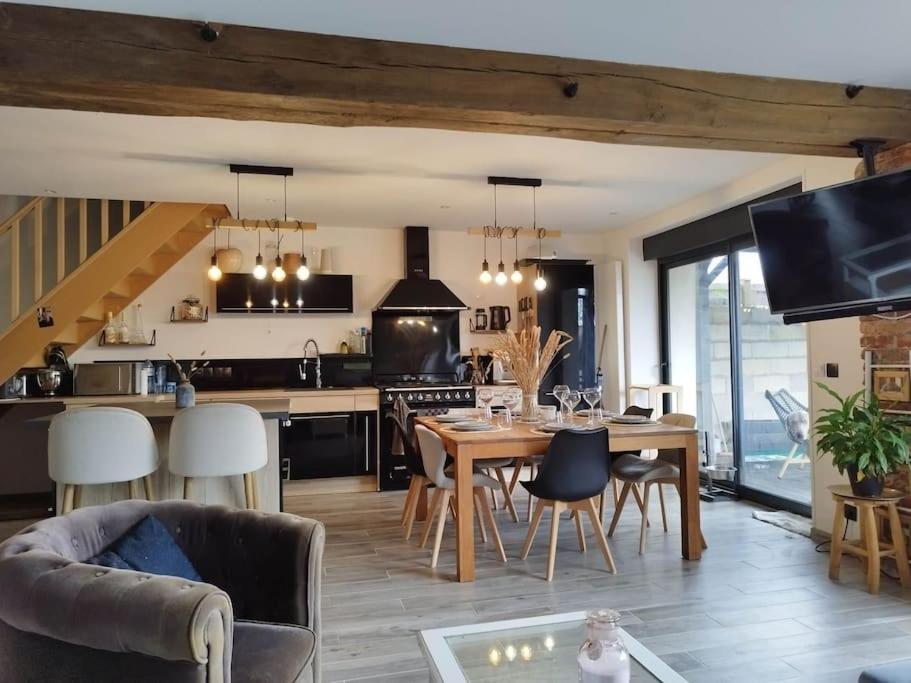 une cuisine et un salon avec une table et des chaises dans l'établissement Maison familiale avec jardin 12' Disney 40'Paris, à Coutevroult