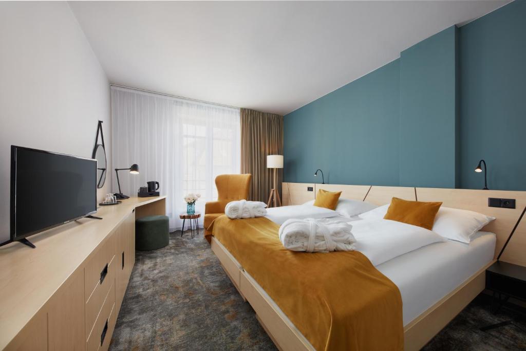 a bedroom with a large bed with a flat screen tv at Spa Hotel Felicitas in Poděbrady
