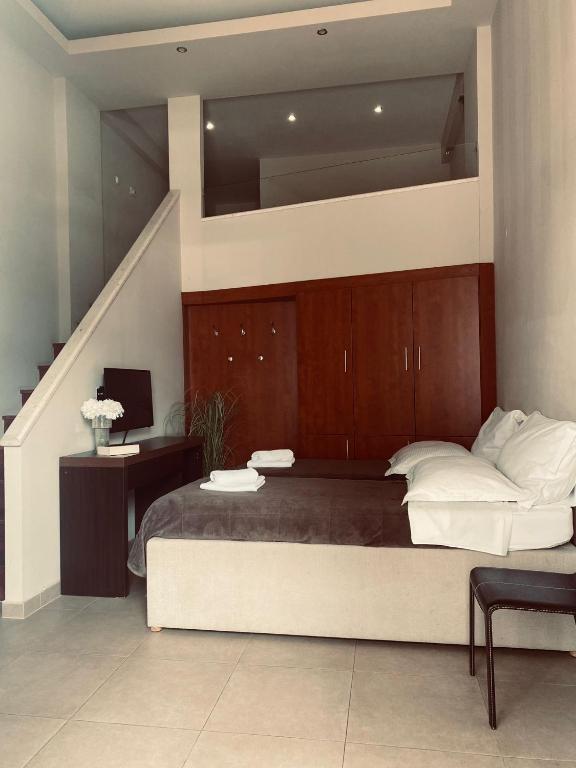 a bedroom with a large bed and a staircase at Božikovina Beach Rooms in Podstrana