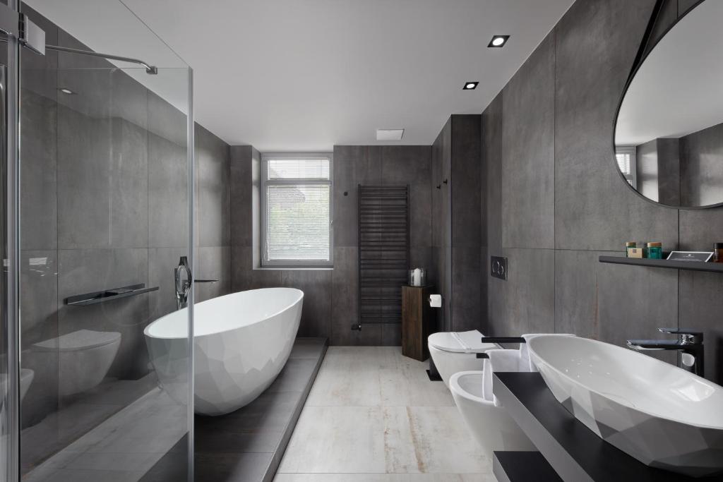 a bathroom with two sinks and a tub and a mirror at Spa Hotel Felicitas in Poděbrady