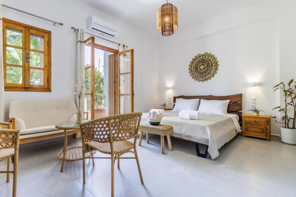 a bedroom with a bed and a table and chairs at Yianna Sunny Studios in Skopelos Town