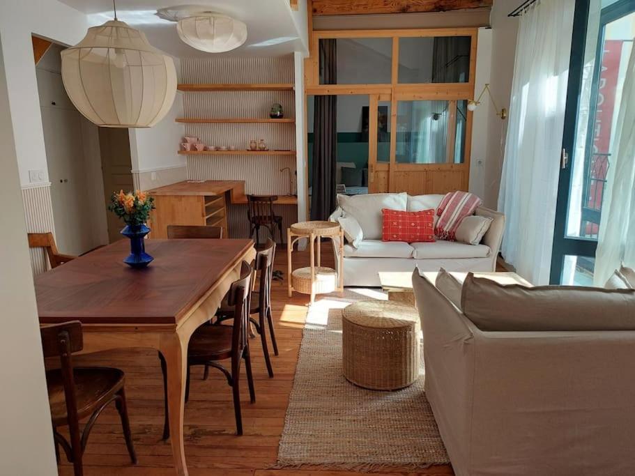 a living room with a table and a couch at Magnifique Appartement le Nid des Thermes in Bagnères-de-Bigorre
