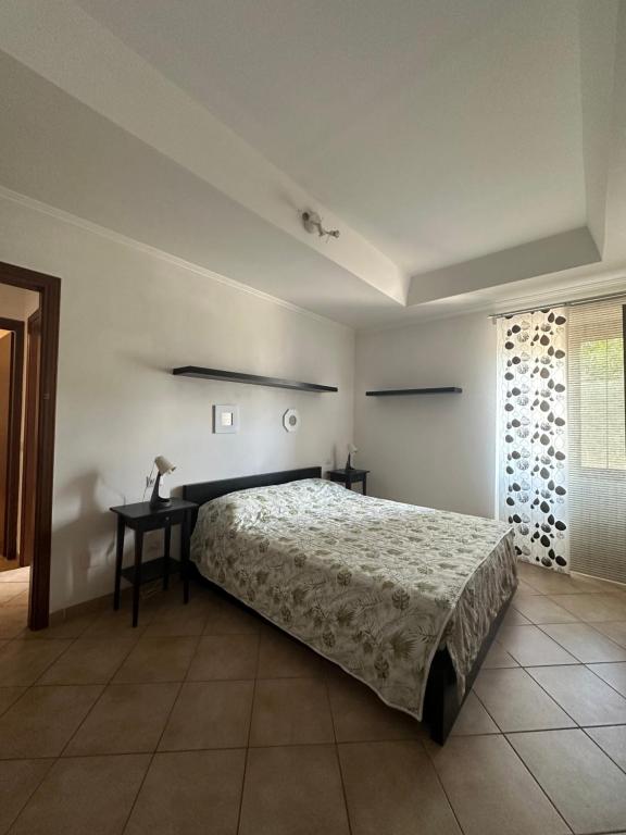 a bedroom with a bed and a table and a window at Appartamenti Sole e Lago in Gravedona