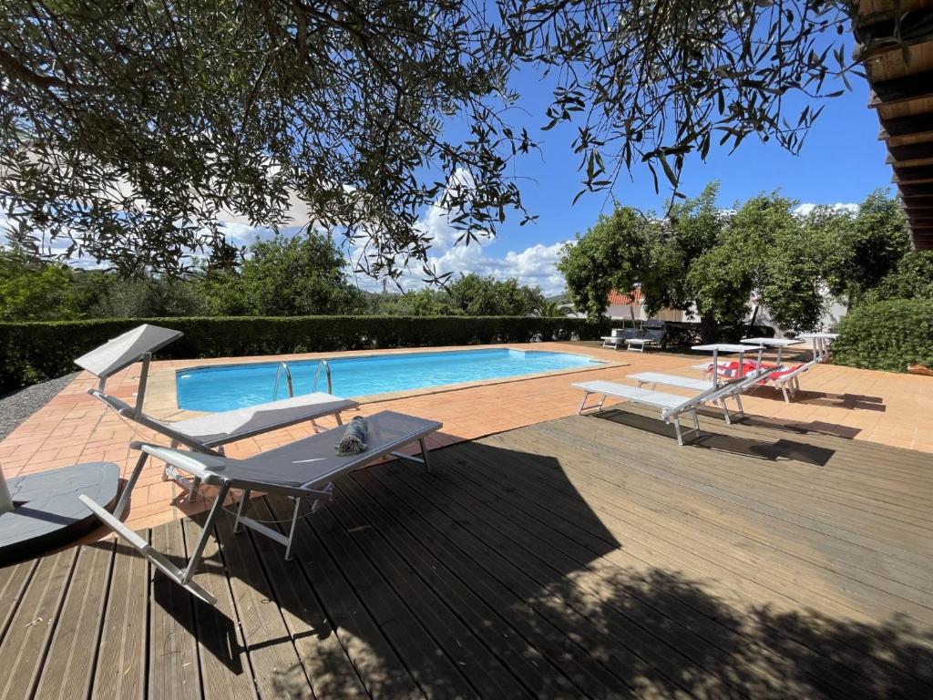 een zwembad met een tafel en stoelen ernaast bij Villa Horta do Limão 8-10 pessoas a 4 km das praias da Ria Formosa Fuseta in Moncarapacho