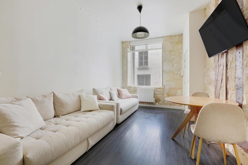 un salon avec un canapé blanc et une table dans l'établissement le zebre, à Paris