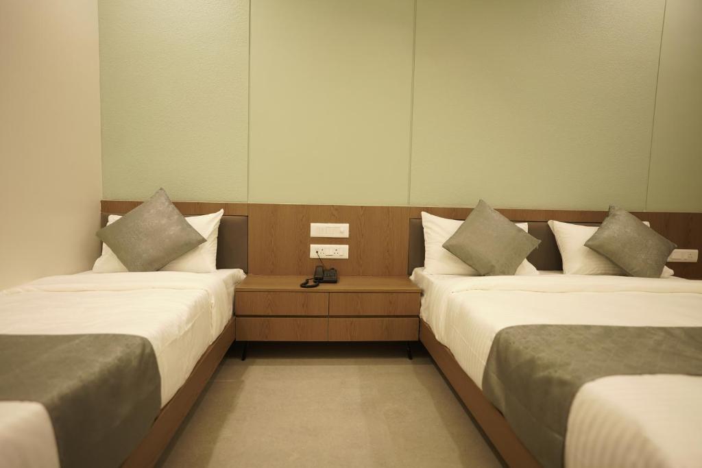 Postel nebo postele na pokoji v ubytování A Square Executive Hotel