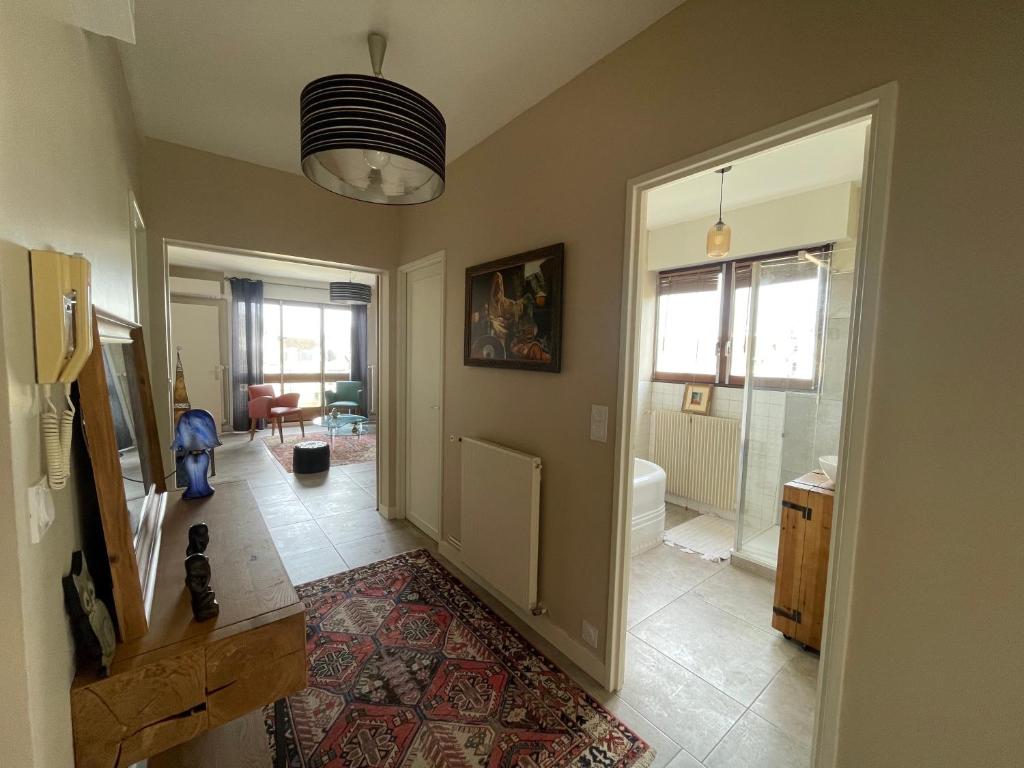 un couloir d'une maison avec une porte et une salle de bain dans l'établissement F2 Résidence Choisnin, à Châtellerault