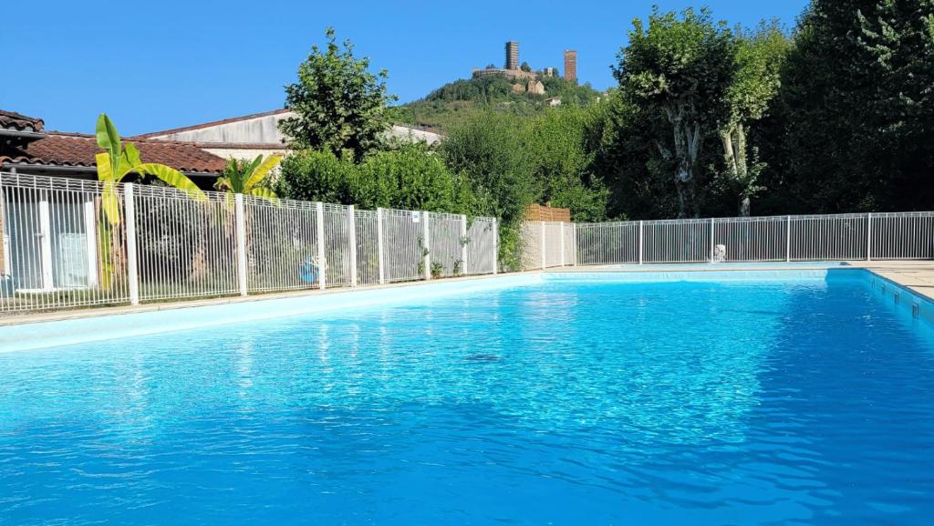 une grande piscine bleue à côté d'une clôture dans l'établissement Camping Le Soulhol, à Saint-Céré