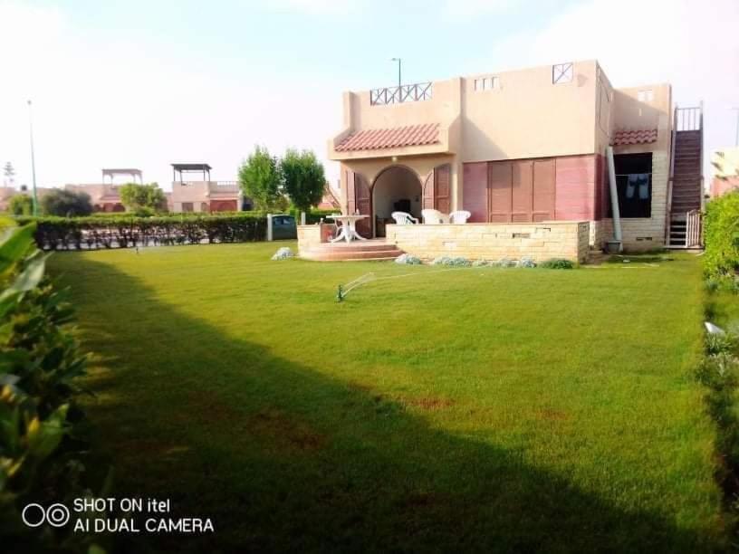 a large yard with a building in the background at Summer Doors - Families Only in Dawwār ‘Abd Allāh