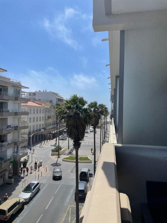 - une vue sur une rue de la ville avec des voitures et des palmiers dans l'établissement Appartement T2, à Canet