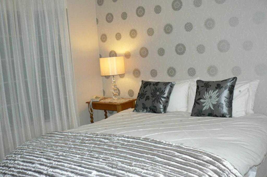a bedroom with a bed with two pillows on it at Fully Furnished 3 Bedroom House In in Pentagon Park Bloemfontein in Bloemfontein