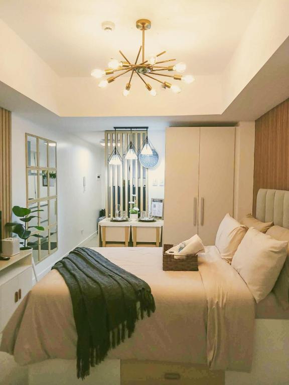 a bedroom with a large bed and a chandelier at Sam's Chic Space - An Aesthetic Getaway in Angeles