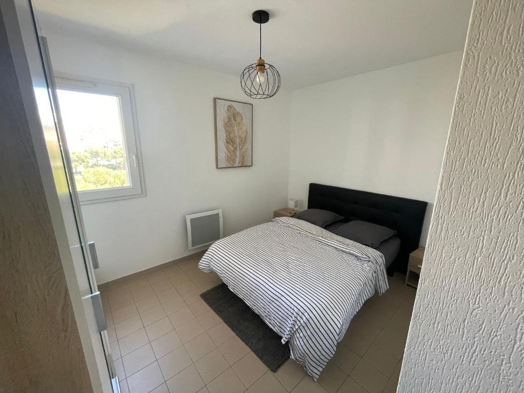 une chambre avec un lit et une fenêtre dans l'établissement Lumineux T2 - Ajaccio proche mer, à Ajaccio