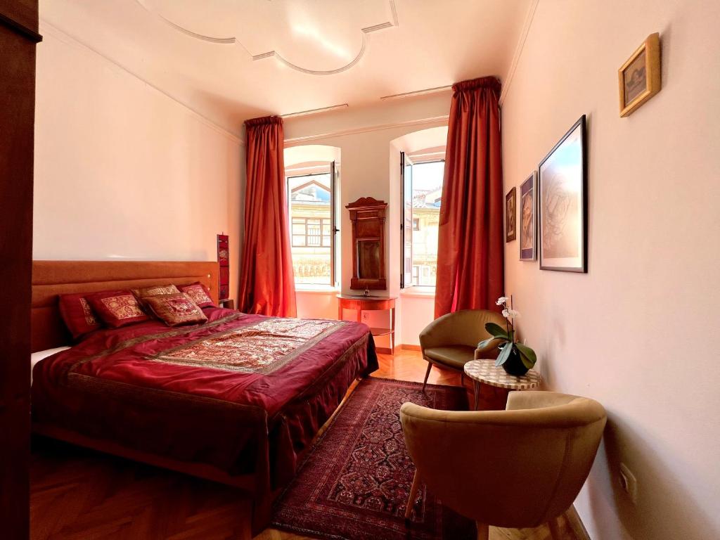 a bedroom with a red bed and a chair at Diana's Chamber in Pula