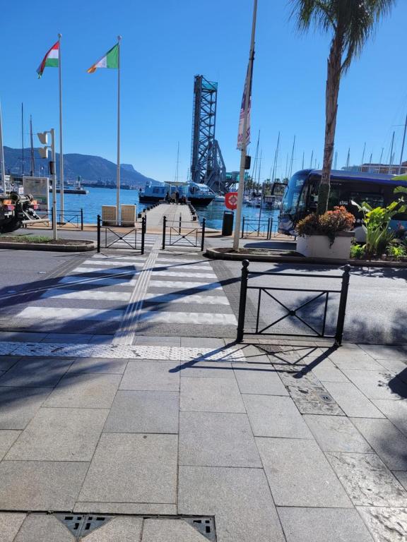 a row of benches on a sidewalk near the water at Joli rez de jardin in La Seyne-sur-Mer