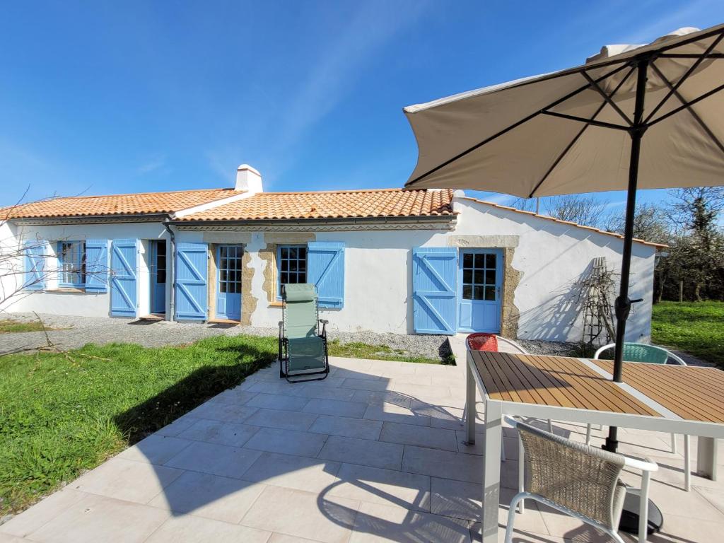 une maison avec une table et un parasol dans l'établissement Maison Paisible, à Saint-Jean-de-Monts