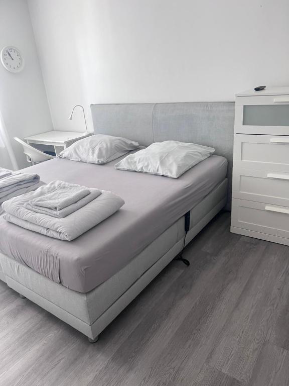 a bed with white sheets and pillows in a bedroom at Moderne 3-Zimmer-Ferienwohnung bei Frankfurt - frisch renoviert, zentral gelegen und perfekt für Familien und Business-Trips in Egelsbach