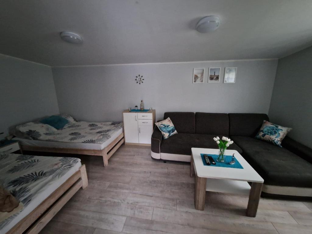 a living room with a couch and a table at Leśny Zakątek - Domek Morze in Ustka