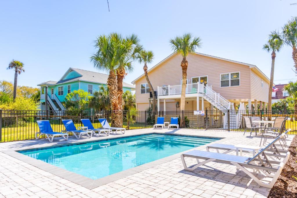 una piscina con sedie e una casa di Down River a Edisto Island