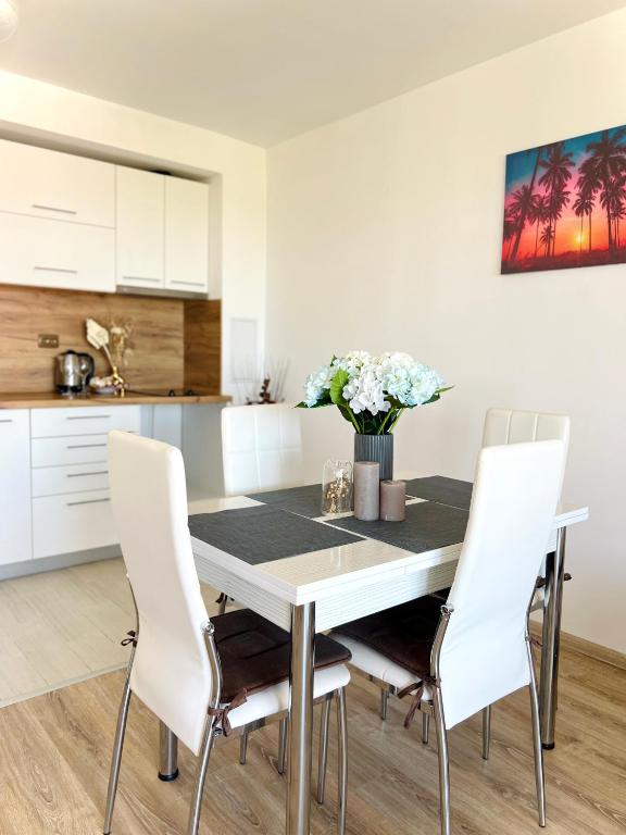 a kitchen and dining room with a table and chairs at Summer Apart Janet in Obzor