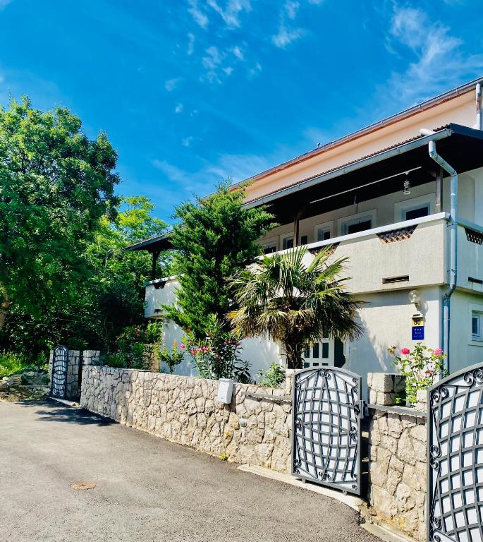a stone fence in front of a house at Studio Lokvica in Omišalj