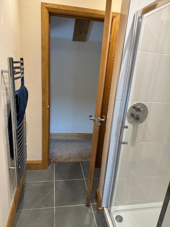 a bathroom with a shower and a glass door at Dovecot in Altarnun