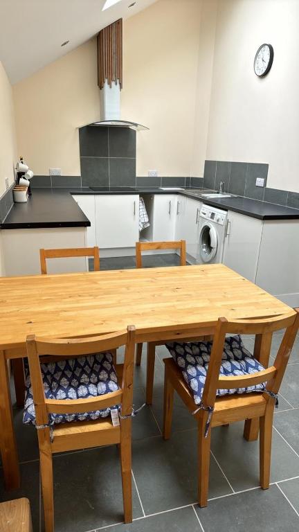 a kitchen with a wooden table and chairs in it at Dovecot in Altarnun